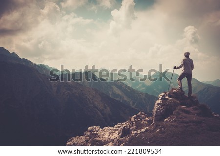 Woman hiker on a top of a mountain  Royalty-Free Stock Photo #221809534