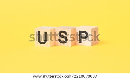 usp - text on wooden cubes, yellow background