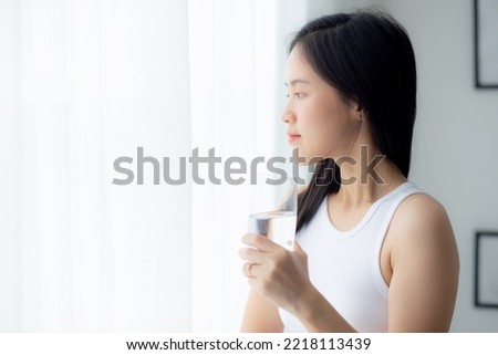 Beautiful young asian woman drinking glass of water mineral pure with fresh and happy at home, asia female drinking beverage for healthcare and weightloss, one person, lifestyles concept. Royalty-Free Stock Photo #2218113439