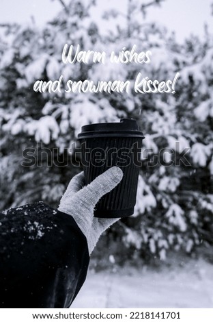 Warm wishes and snowman kisses Inspiration joke quote phrase Female hand in winter warm gloves holding black eco paper cup. Creative trendy zero waste recycle cup. Hot warming drink winter day