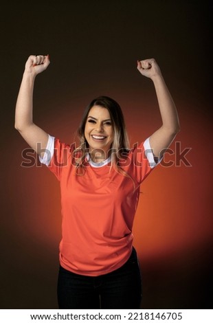 woman soccer fan cheering for her favorite club and team. world cup orange background.