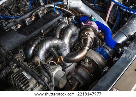 Welding fabrication stainless steel turbocharged and wastegate exhaust manifold headers , in turbocharged racing car. Royalty-Free Stock Photo #2218147977