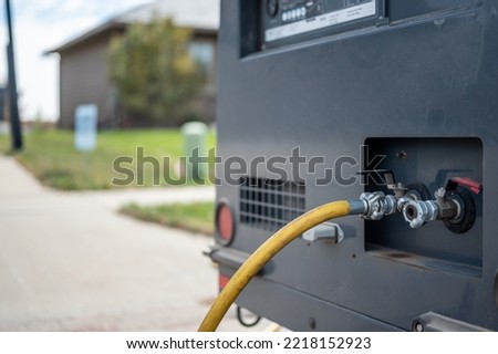 Winterizing a residential irrigation system by using a compressor and forced air to blow the lines empty. Royalty-Free Stock Photo #2218152923