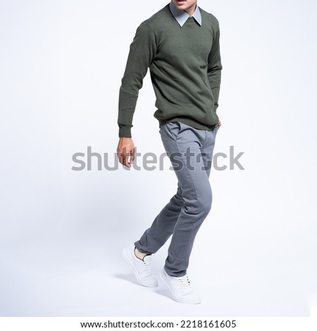 Man wearing sweater green and shirt with grey chinos and white shoes Royalty-Free Stock Photo #2218161605