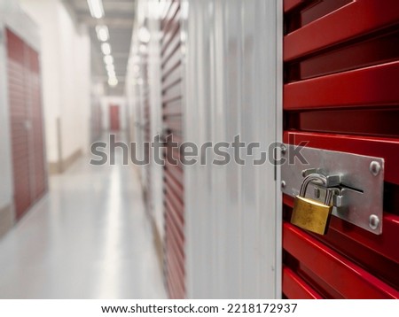 Lock on a red color metal door of a self storage facility. Selective focus. Nobody. Keeping your staff safe concept. Royalty-Free Stock Photo #2218172937