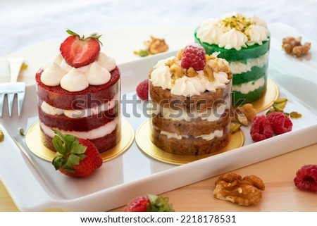 Cap-cake with cream and strawberry on a table
