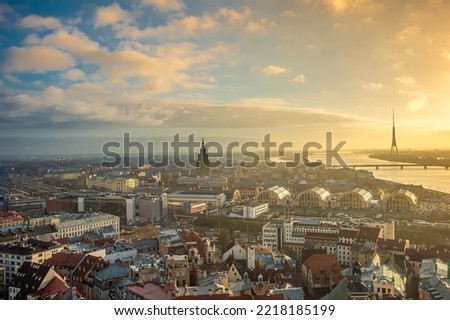 Panorama of the city of Riga on a sunny day, blue sky, morning, sunset, a view of the old town, narrow streets, red brick roofs of houses, a river and bridge. Can be used for websites, brochures.