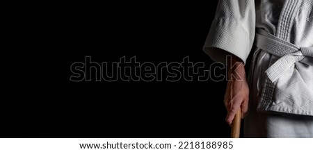 A person practicing aikido martial art on a black background. Royalty-Free Stock Photo #2218188985