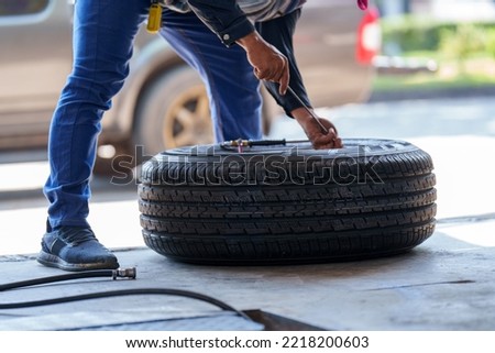auto mechanic repairman changing wheel and tire in a workshop	