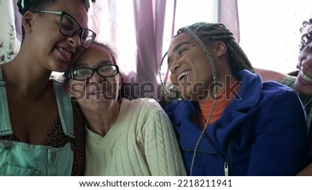 Adult daughter kissing senior mother on the cheek. Happy South American hispanic people showing love and affection