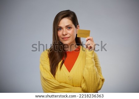 Smiling woman in yellow holding credit card and ready for payment. Isolated female advertising portrait.