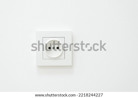 Electric outlet on a white wall. White inked wall with electric socket Royalty-Free Stock Photo #2218244227