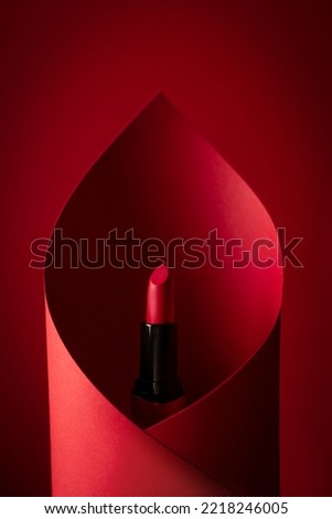 red lipstick wrapped in red paper on a red background