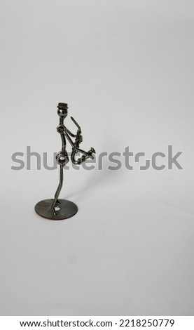 handicrafts in the form of miniature people playing the saxophone. This handicraft is made of bolts, nuts and other iron