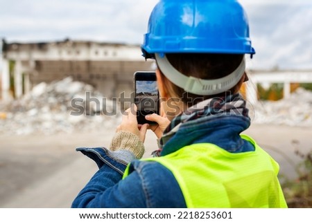 Surveyor takes a photo of the construction site. Worker in a helmet at a construction site