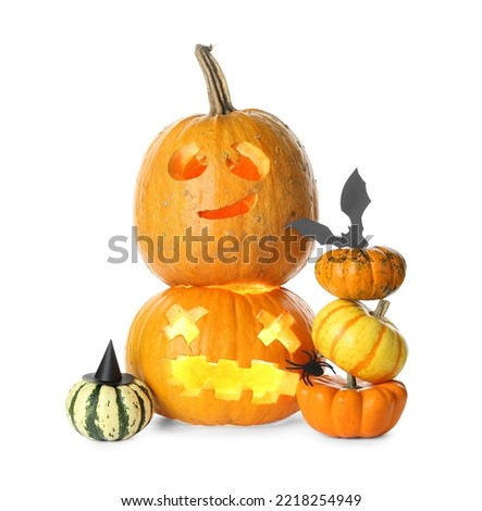 Carved Halloween pumpkins with paper bat on white background
