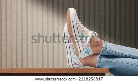 Young traveler woman wearing canvas shoes decorated with city names Royalty-Free Stock Photo #2218256817