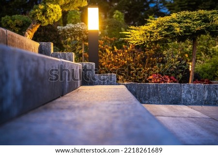 Outdoor Garden Light Installed Along Concrete Backyard Stairs Lighting Them Up in the Evening. Landscaped Garden in the Background. Royalty-Free Stock Photo #2218261689