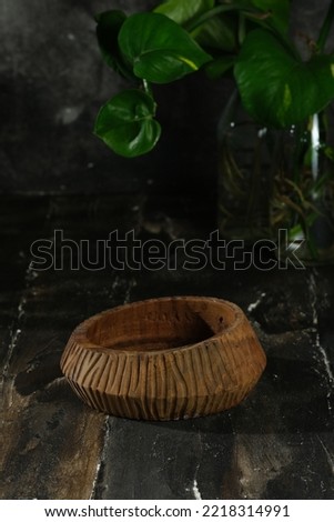 Wooden bowl on rustic background . It is handmade. plant in bottle in the back. Mangkok Kayu 