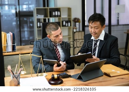 Business team and lawyers discussing contract papers sitting at the table. Concepts of law, advice, legal services. at modern office