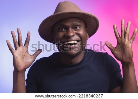 Overjoyed impressed african american man raise opened hands palms surprised wow happy emotions on pink and violet color background