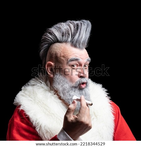 New Year and Christmas in the company of an unusual bad Santa. Dangerous gray-haired old man Santa. Tobacco smoking crazy Santa claus with mohawk.