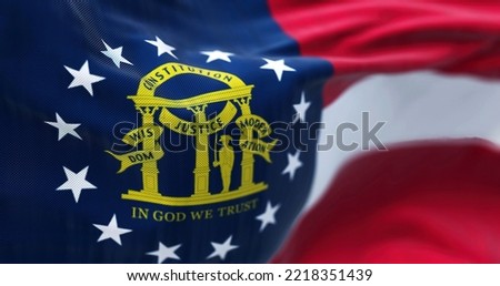 Close-up view of the Georgia state flag waving in the wind. Georgia is a federated state of the United States of America. Fabric textured background. Selective focus