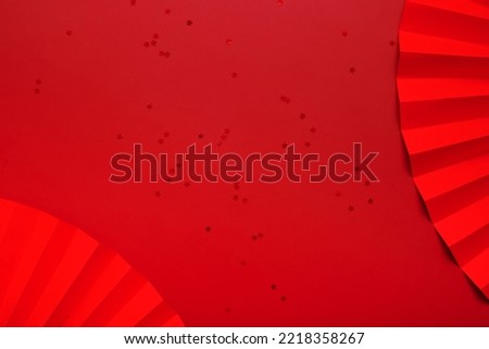 Red paper fan and stars. Monochrome new year background top view with copy space.