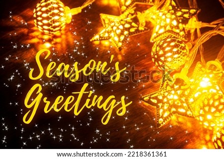 Season's greetings text with golden ball and star of Christmas decoration. Season's greetings and Christmas celebration concept.
