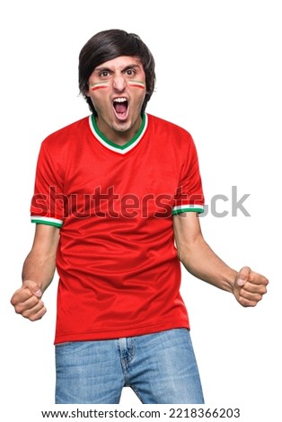 Soccer fan man with jersey and face painted with the flag of the IR IRAN team screaming with emotion on white background. Royalty-Free Stock Photo #2218366203