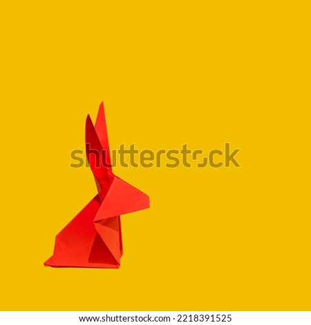 Creative greeting card design made of red paper rabbit on a vibrant yellow background. Lunar, Chinese New Year composition for 2023. Year of the Rabbit.