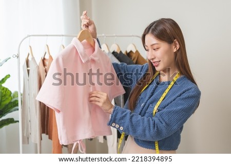 Young small business woman prepare used clothes to sell on internet.
