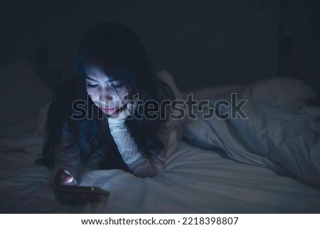 Asian woman playing game on smartphone in the bed at night,Thailand people,Addict social media Royalty-Free Stock Photo #2218398807
