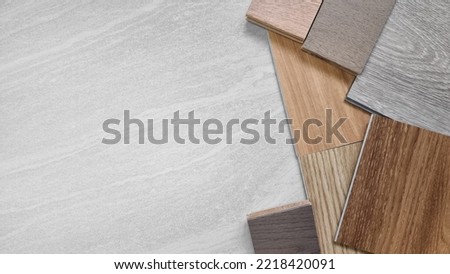 samples of interior material, wood, on travertine marble table with blank space. interior design selected material including various type of engineering and vinyl flooring tiles for construction. Royalty-Free Stock Photo #2218420091