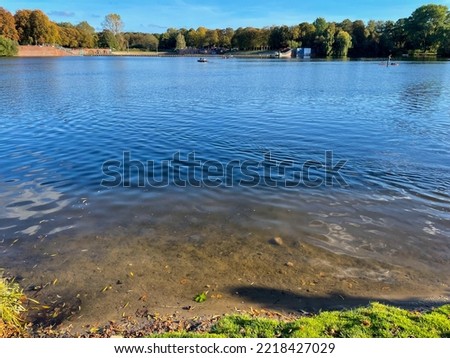 Beautiful Hamburg Stadtpark lake landscape, water pond surface and trees in autumn time