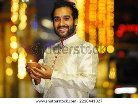 young indian Boy holding diya to celebrate diwali and wearing dress traditional ethnic wear