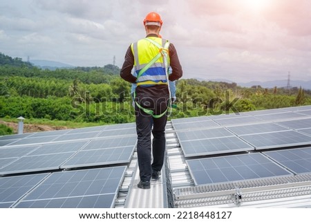 Professional worker installing and checking solar panels on the roof of a factory,Innovative solution for energy solving. Use renewable resources. Green energy.