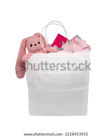 White paper shopping bag. Gifts and toys for girls.
