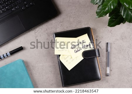Quiet Quitting. Workplace desk with laptop computer, office supplies, potted plant. Closed paper business notebook planner with sticker with written text Quiet Quitting. Top view Royalty-Free Stock Photo #2218463547