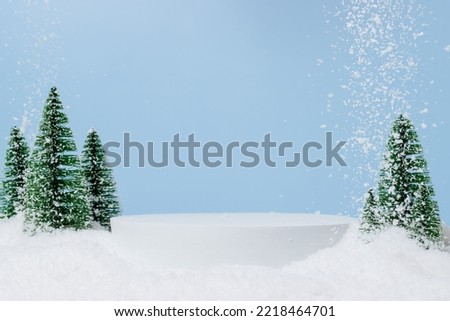 White podium with fir trees and falling snow. Display for winter holidays, New Year and Christmas product presentation Royalty-Free Stock Photo #2218464701