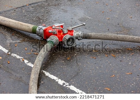 fire hose distributor red on asphalt
