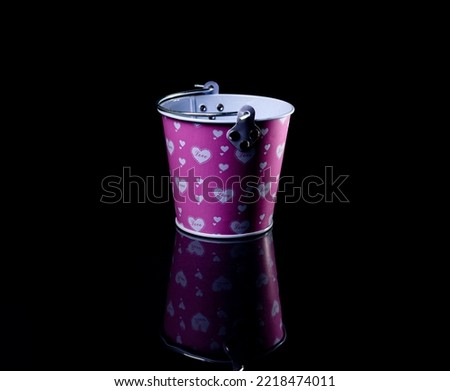 Many aluminum ice bucket laid in wait for use. many stainless multi-colored buckets with reflection, black background isolated,