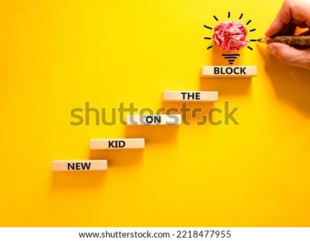 New kid on the block symbol. Concept words New kid on the block on wooden blocks. Businessman hand. Beautiful yellow table yellow background. Business and new kid on the block concept. Copy space.