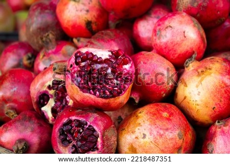 Juicy, tasty, ripe Georgian pomegranate. Photograph of a fruit stand in a Tbilisi market. Red fruits of a southern plant. The concept of healthy eating and buying farm products. Small business support