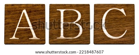 The first three letters of the English alphabet: ABC. Brown wooden cards. Light letters on a white background