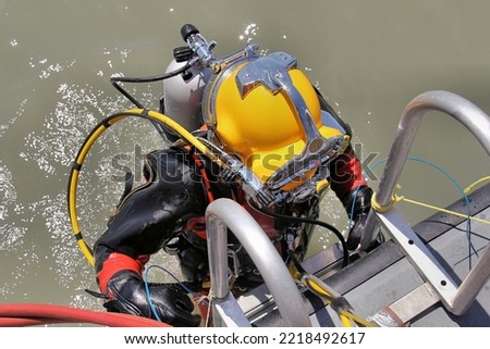 Commercial Diver Helmet Exiting Water Royalty-Free Stock Photo #2218492617