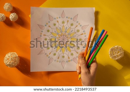 Female painting mandalas antistress page to combat stress. Relaxing hobby mental wellbeing and art therapy. Woman paints sketch, meditative process of coloring pages. Self expression by art 
