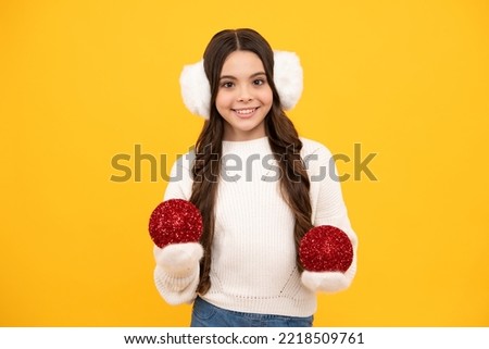 Winter holidays concept. Cheerful teenage girl in xmas sweater wishing merry Christmas, standing against yellow background.