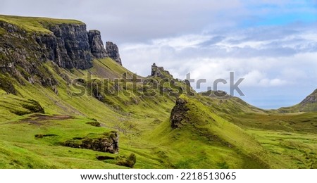 Beautiful,dramatic Scottish mountainous scenery,pointed,jagged mountain peaks and sheer cliff faces, along the Quiraing hills walk,green grass and shrub covered in the mid summer,north eastern Skye. Royalty-Free Stock Photo #2218513065