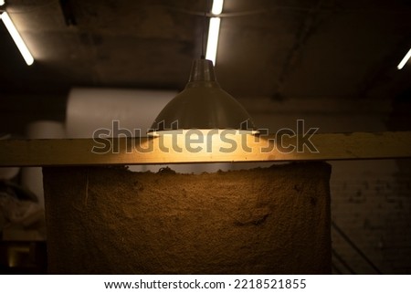 Lamp hangs on ceiling. Lamp shines indoors. Interior details. Warm Light.